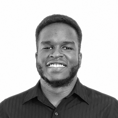 Black and White portrait, Jeremiah smiles for the camera wearing a dark collared shirt