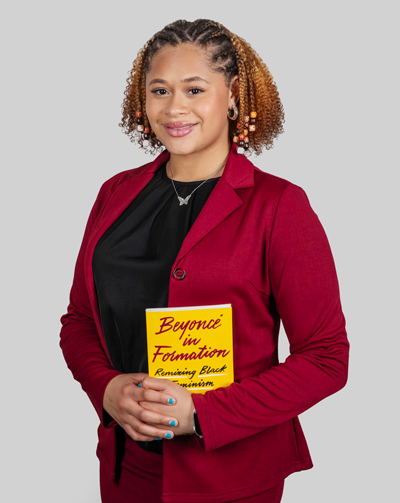 Alanna Herbert ’29 poses with a book about Beyoncé