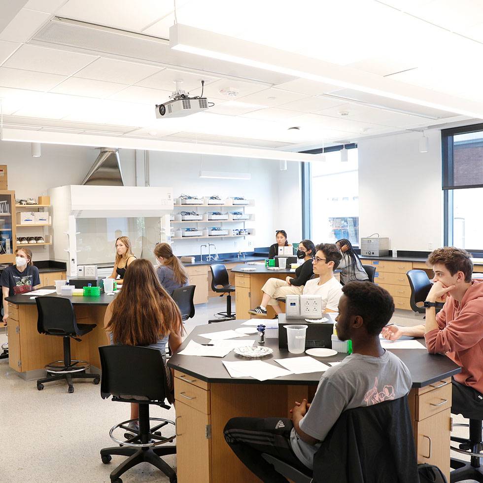 Students sit listening in a science lab classroom 