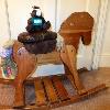 Skids sits atop a wooden hobby horse, a distant cousin.