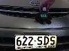 "Down Under" him, Skids shows off the first Australian license plate he finds in Queensland, the Sunshine State. Susan Davidson'71 enjoyed  his sense of humor and noted that SDS was a group on campuses during her college years!
