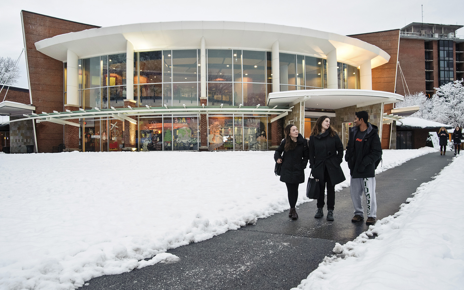 Skidmore students walking in front of the Dining Hall in winter 