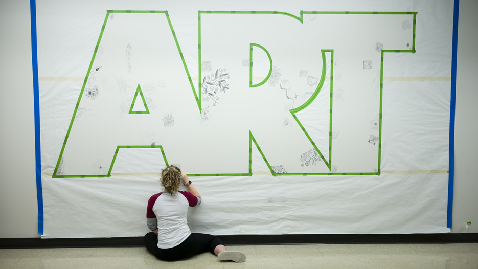 A student works on a mural during the Saisselin Art Center 40th Anniversary Celebration. 