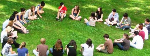 Students sitting in a circle on the grass