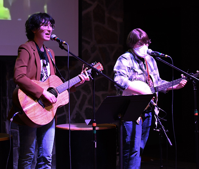 The student duo Question of the Century performs their self-written folk songs.