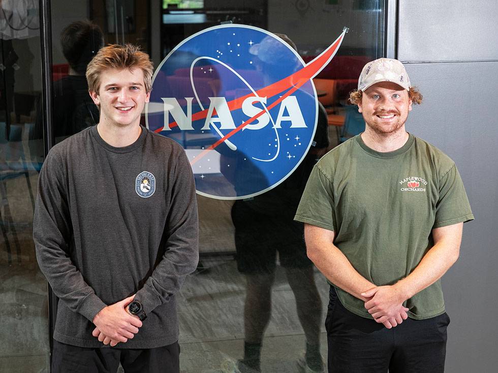 Two students posing at NASA during their experiential learning opportunity