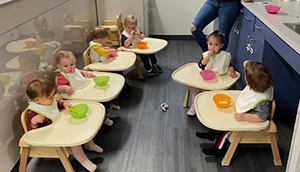 Infants sitting in high chairs at snack time