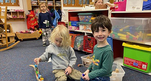Children playing with wooden train set