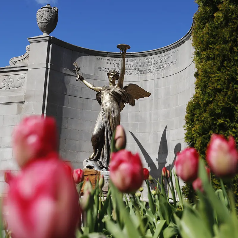 Pink tulips bloom in front of the iconic Spirit of Life statue in Saratoga Springs’ Congress Park, honoring the city’s legacy and natural springs with classical elegance.