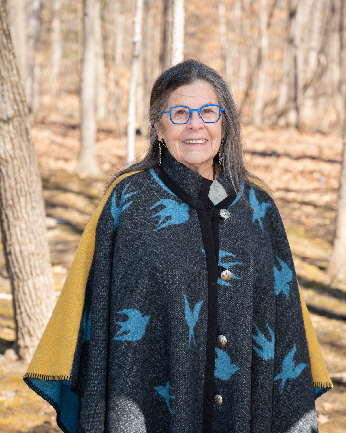 Kay Olan stands in the woods