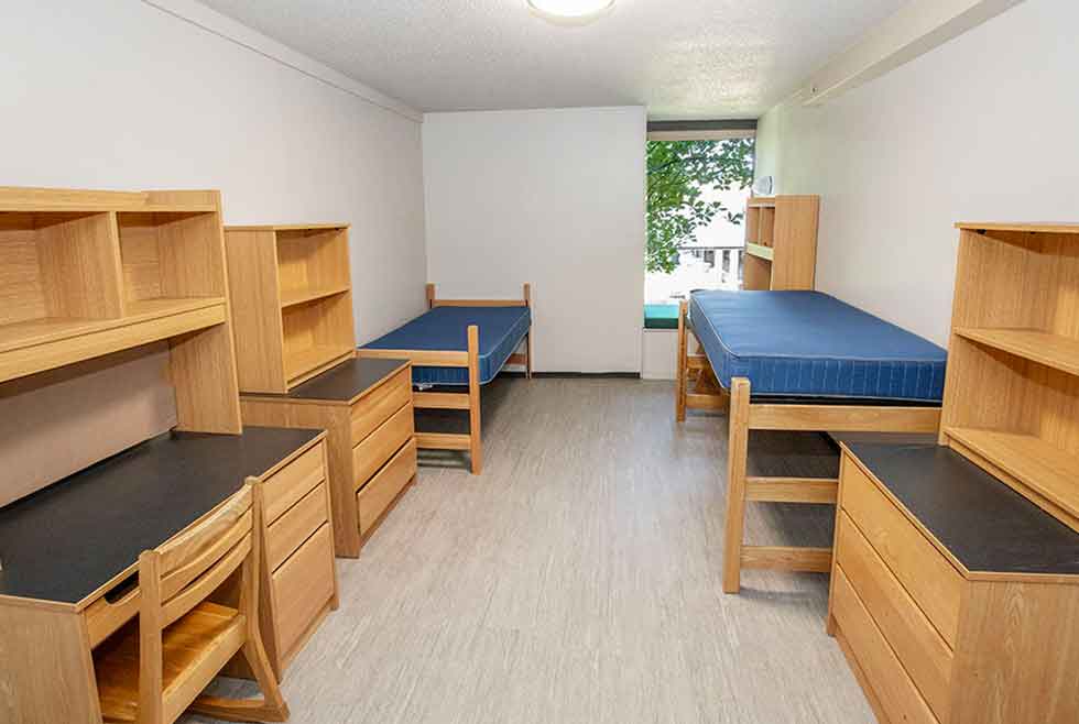 Jonsson residence double room with two beds, desks, shelves, dressers, and a window.