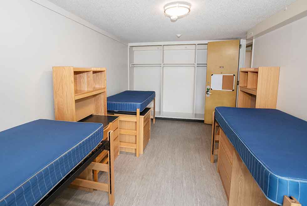 Jonsson residence triple room with three raised beds, closets, desks, shelves, and dressers.