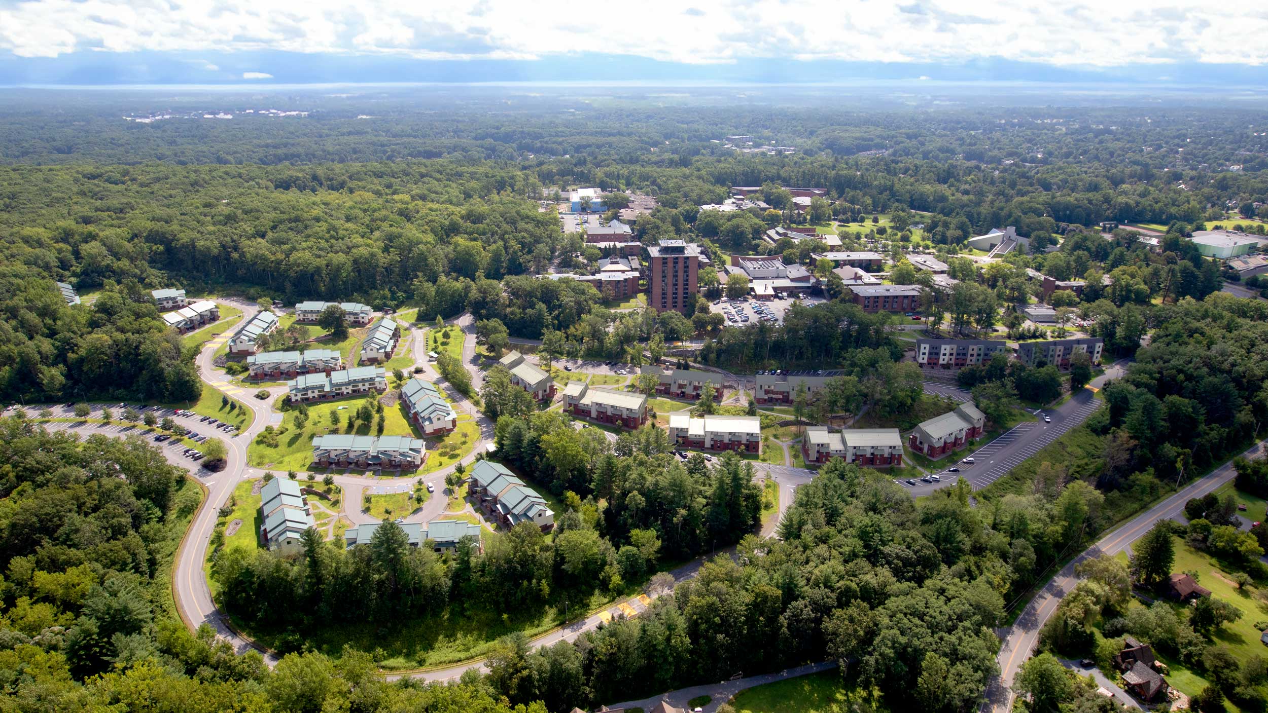 Aerial view of Skidmore College’s campus, residence areas, academic buildings, roads, and surrounding forest.