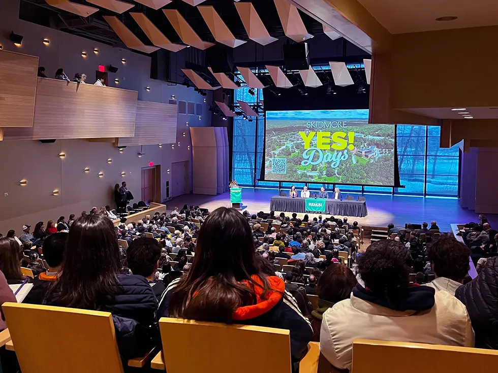 A packed auditorium full of admitted students and families watches a panel on stage during Skidmore’s “YES! Days” event.