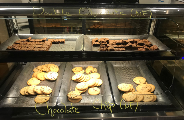 chocolate chip cookies and brownies in a display case