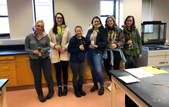 Students in a lab studying flowers