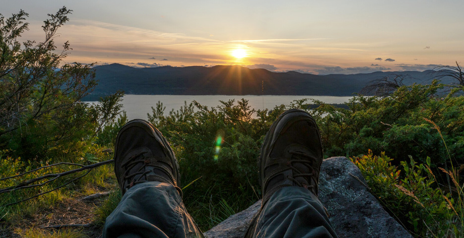 View of a sunset over a mountain from a hiker's perspective