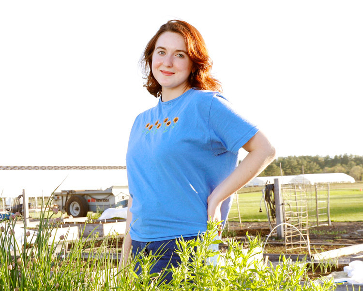 young woman standing in farm field