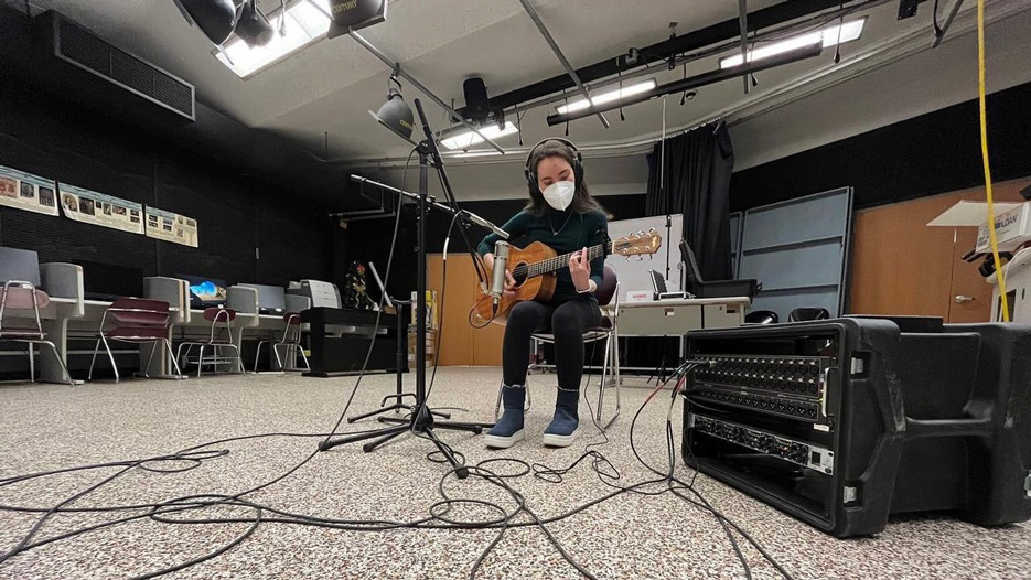 Sarah Libov, a Skidmore College student, plays guitar in a recording studio