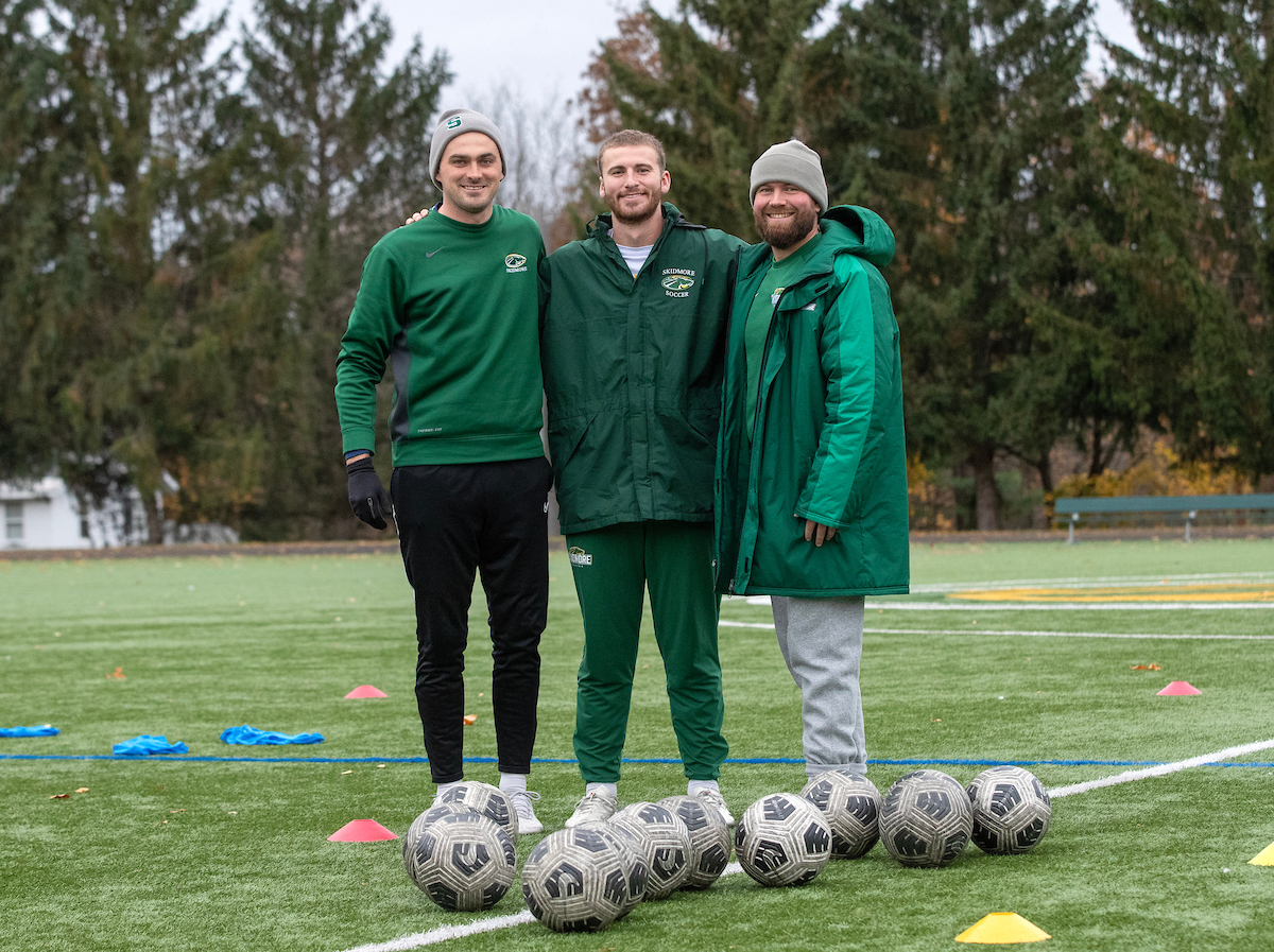 Skidmore Head Men’s Soccer Coach Brad Campion (left), Owen Brady '25, and Assistant Coach Ethan Gunty pause during a break at a training session.
