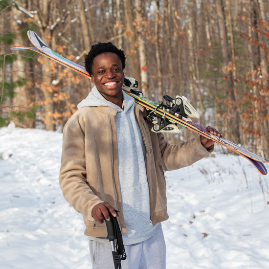 Suleiman+Lailati+%E2%80%9928+holds+a+pair+of+skis+over+his+shoulder.+