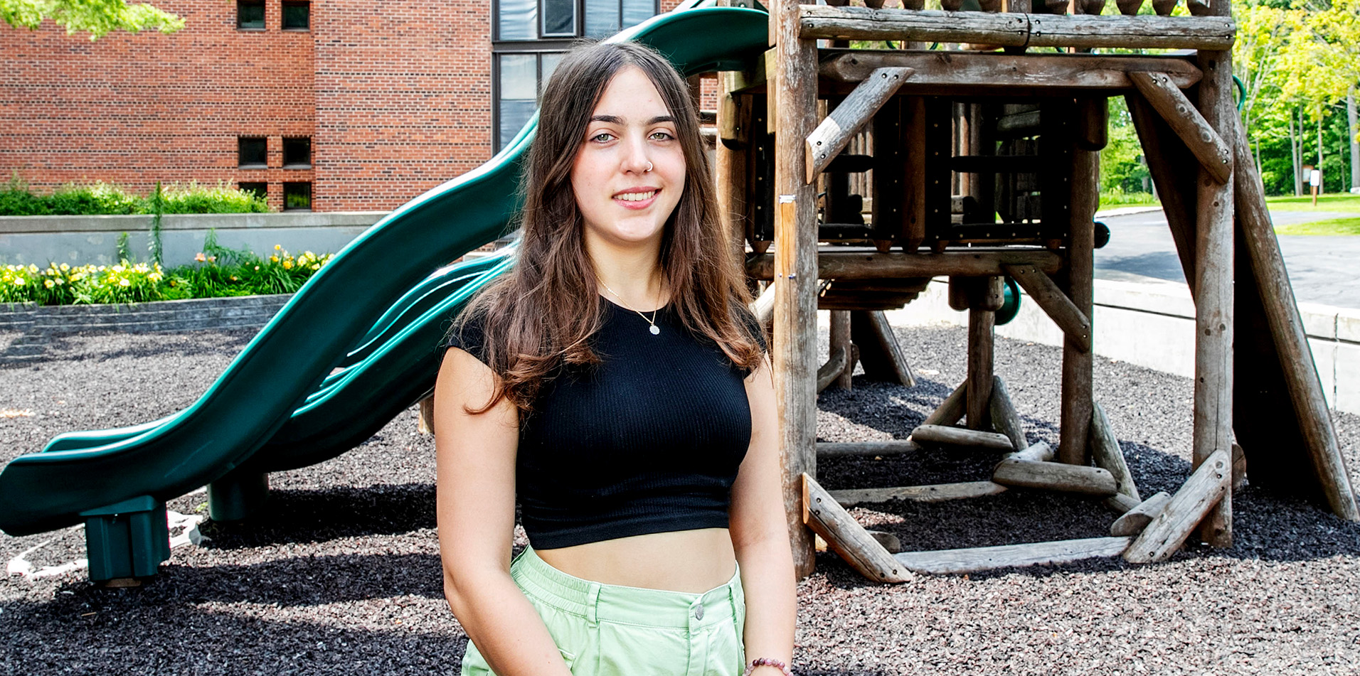 Elena Tittel stands in front of a children's playground