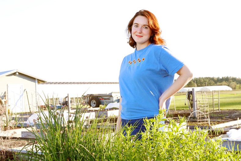 young woman standing in farm field