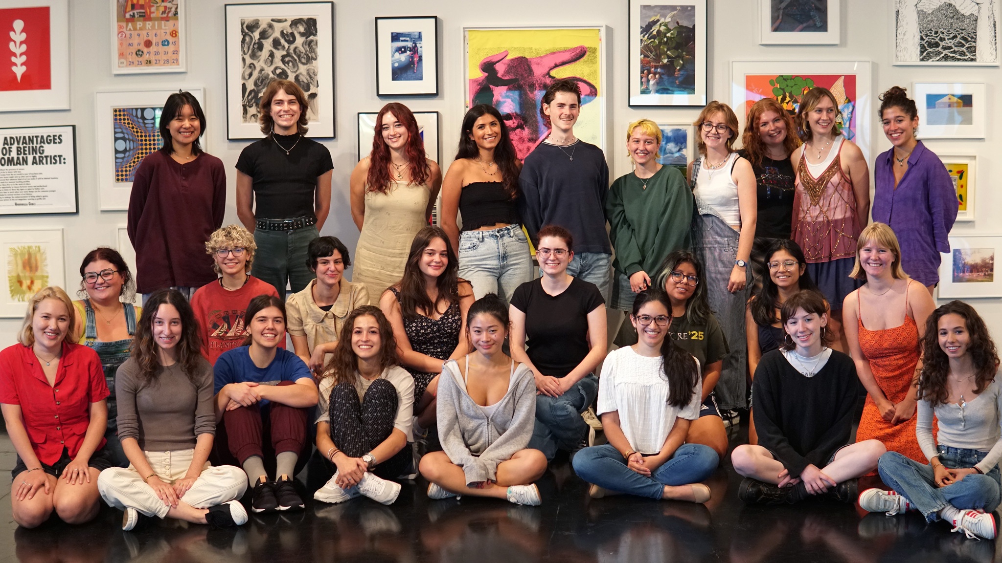 The Tang Student Advisory Council stand and sit against a backdrop of art in the Frances Young Tang Teaching Museum and Art Gallery.