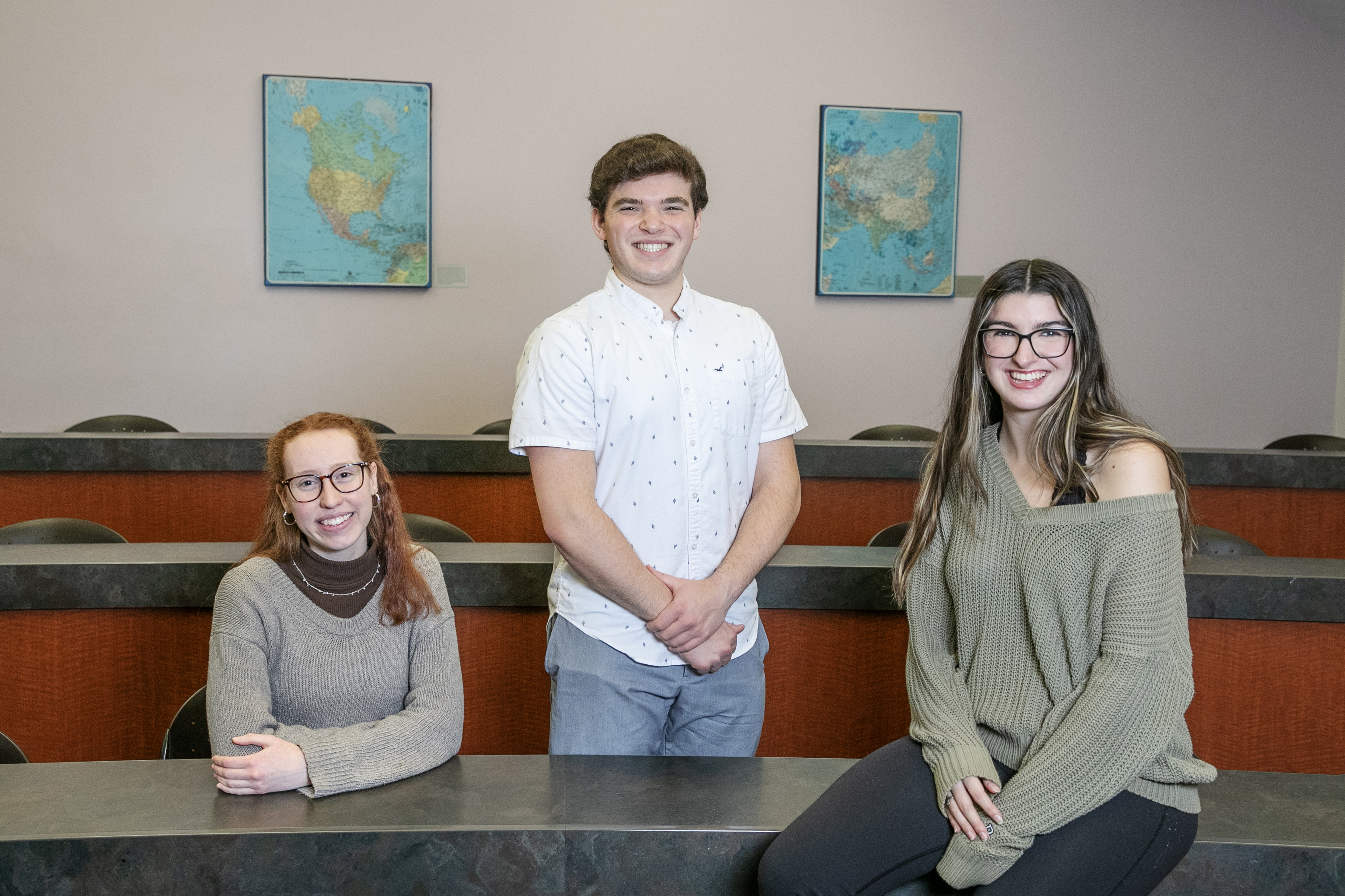 Peer mentors Liz Bracht ’24, Sophia McGowan ’24, and Jackson Smith ’24 smile at the camera in a Skidmore classroom.