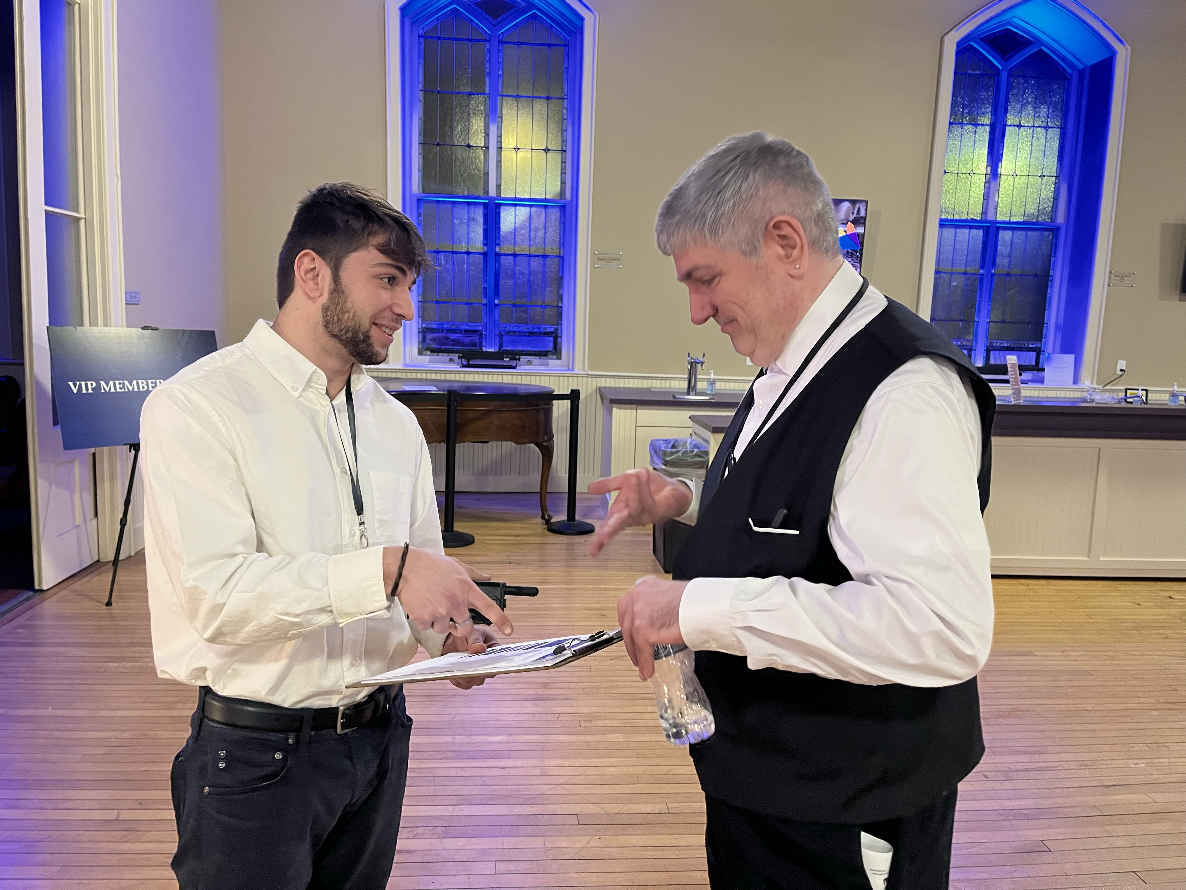 Eli Cott ’25 and UPH volunteer discuss venue preparations before guests’ arrival ahead of a recent performance.