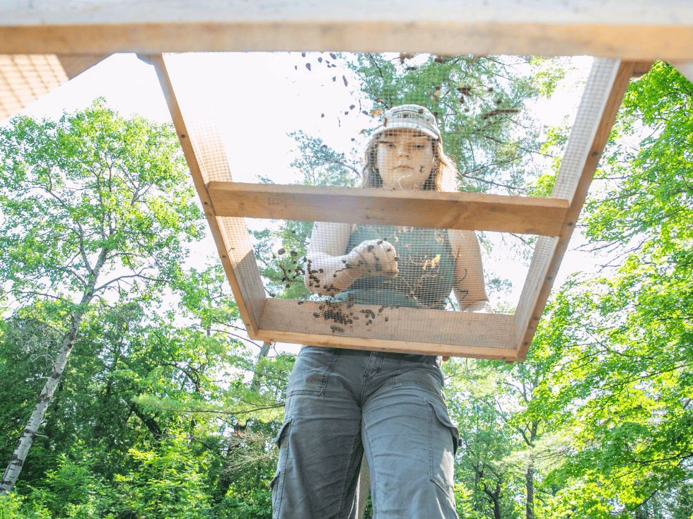 Skidmore College student Lily Whelden ’25 sifts dirt during a dig to excavate artifacts from the site of a Revolutionary War-era smallpox hospital in Lake George Battlefield Park