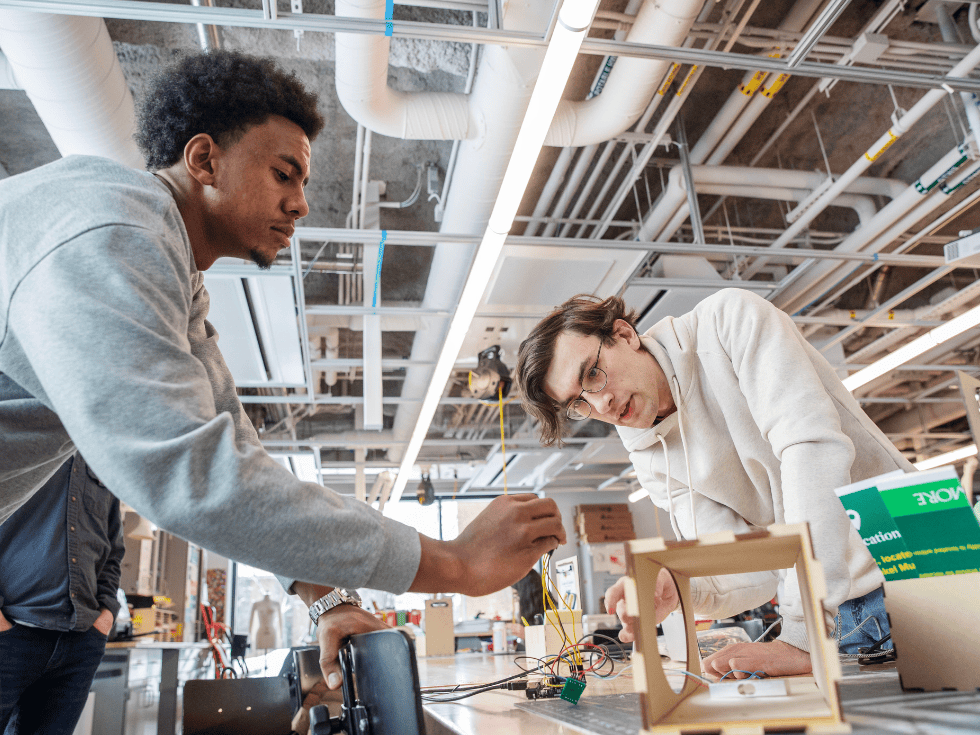 Two students working on developing a project proto-type.
