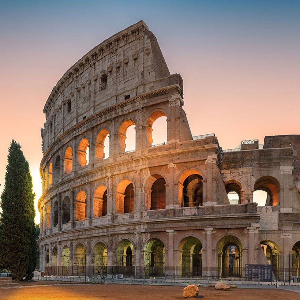 The coloseum with the sun shining through in the background