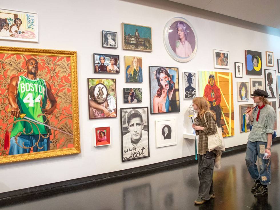 Two students walk along a colorful gallery wall at the Tang Museum, exploring the different artwork displayed.