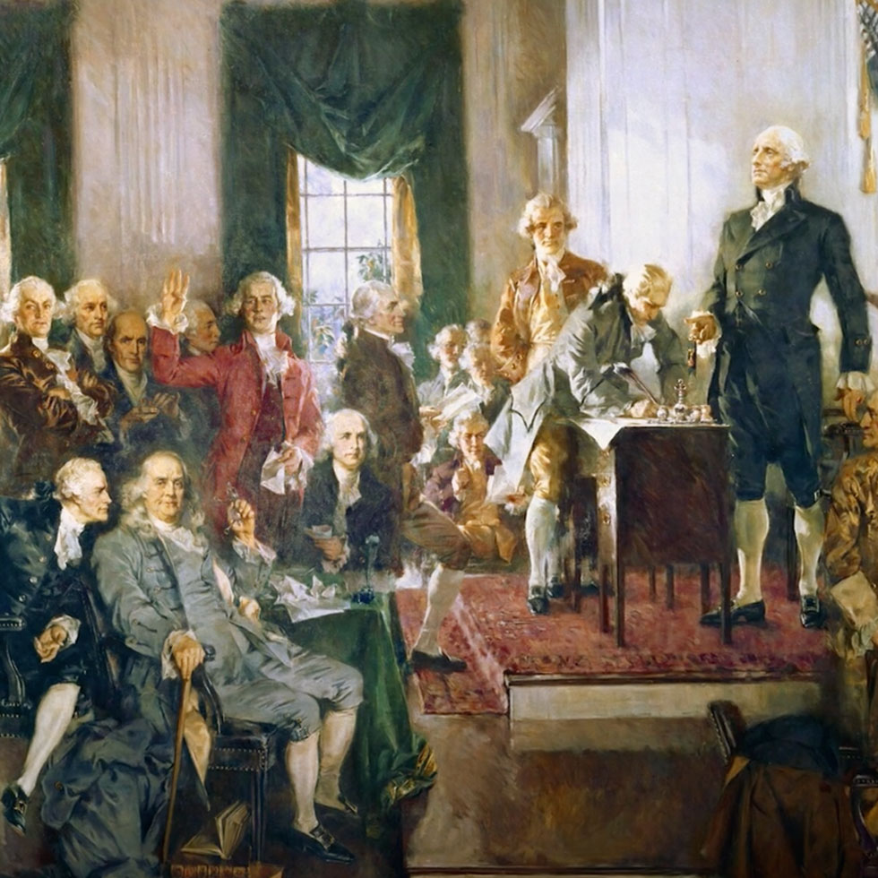 Painting of the 1787 signing of the U.S. Constitution, showing George Washington standing at center and delegates seated and gathered around in Independence Hall.