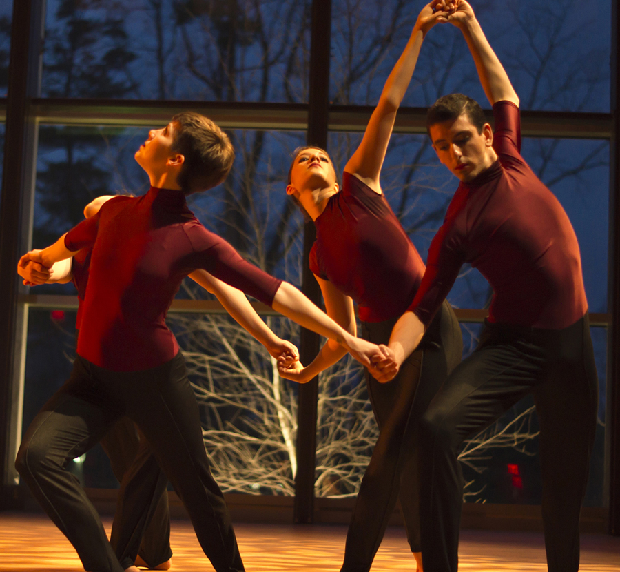 four dancers holding hands ina circle