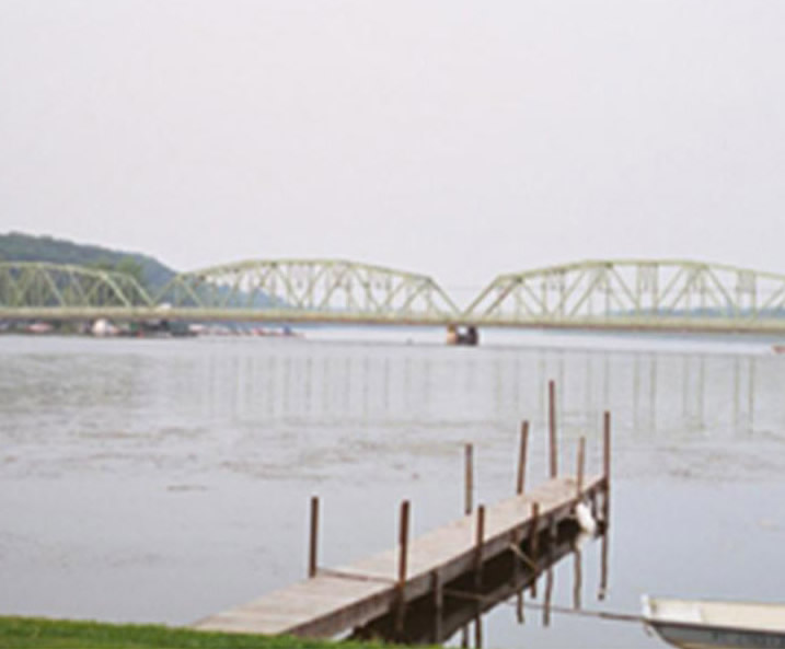 Boat dock on the water, with a bridge in the background