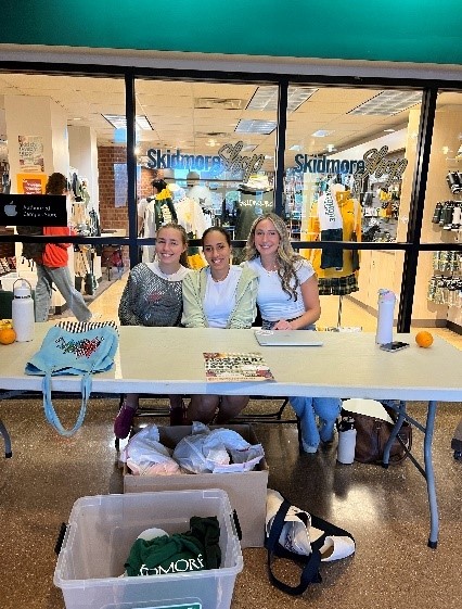 Students sitting at a table outside the skidmore shop