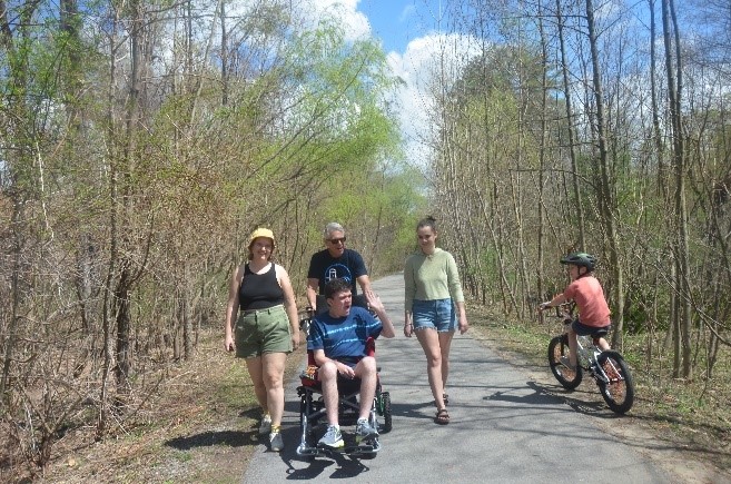 Students enjoying the weather on an accessible woods trail