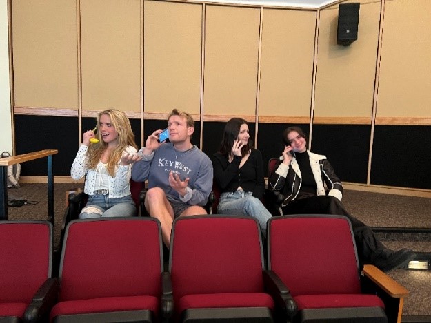 4 students sitting in a theatre