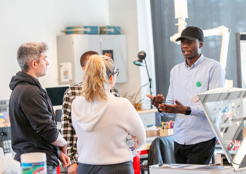 Students and alumni discuss prototypes in the idealab