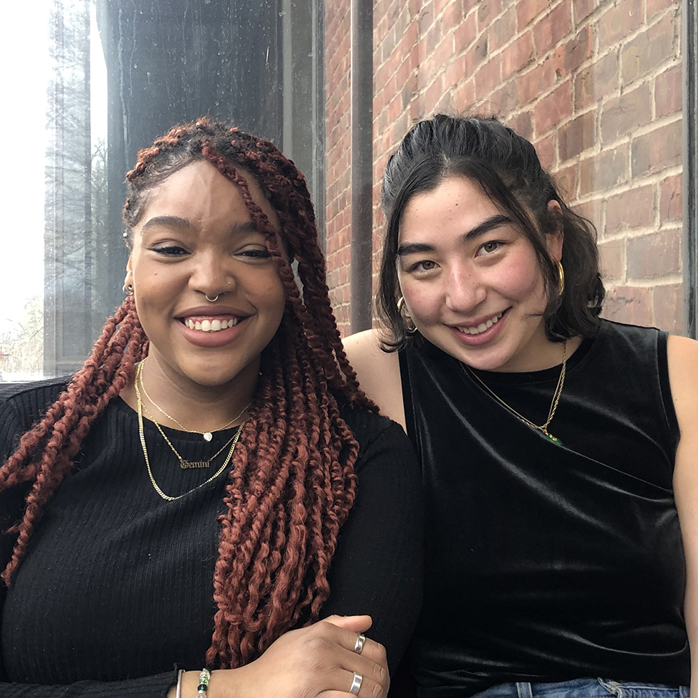 Two students pose together with big smiles