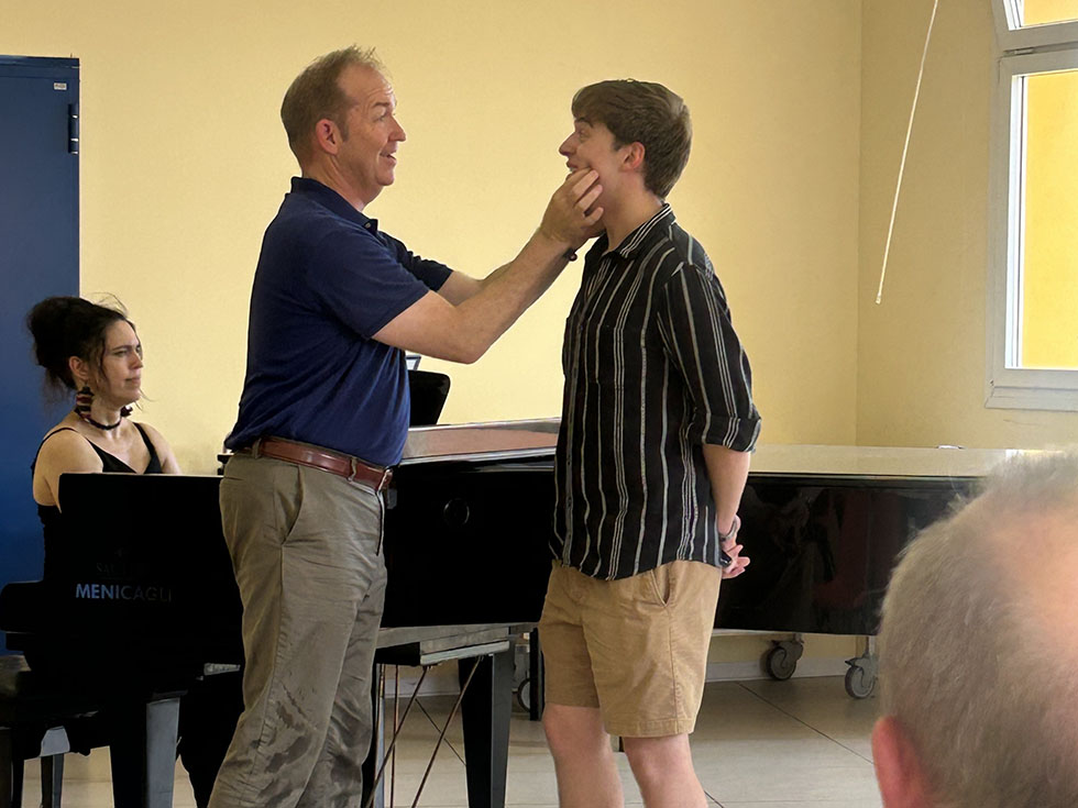 Professor works with voice student by guiding mouth position.
