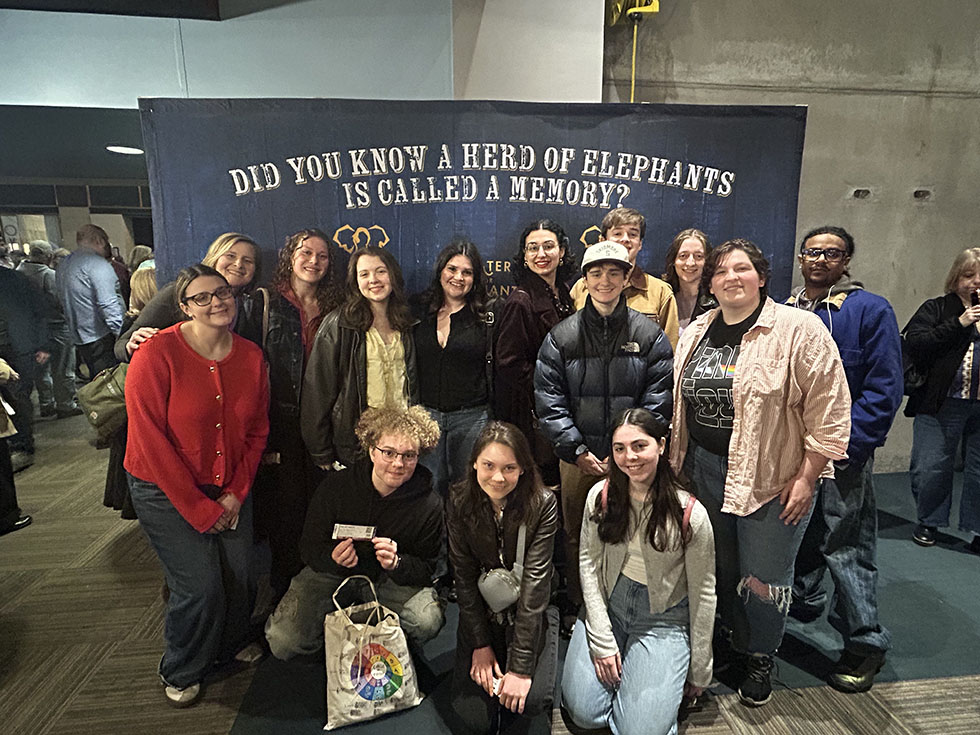 Group poses in front of large sign at Water for Elephants