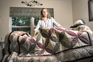 Elisa Smith '18 makes a bed at the Joan Nicole Prince Home. (Photo by Erin Covey)