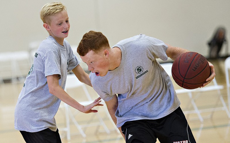 T'bred Pat Gallagher '20 (at right) shares some big moves with a young athlete during a hoops camp for sixth- through eighth-graders.