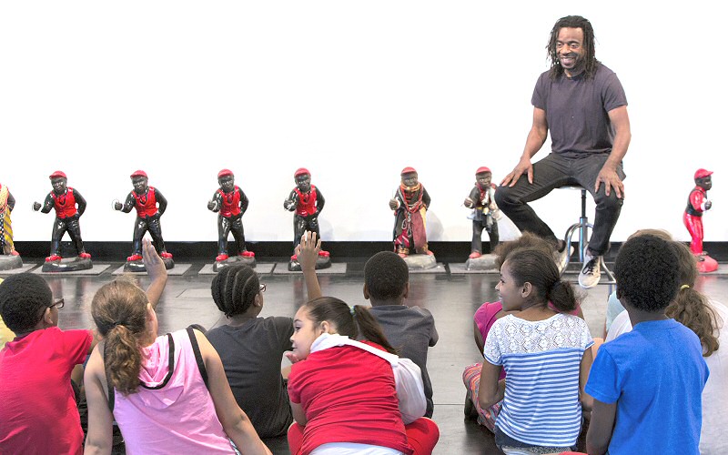 Artist Willie Cole tells the youngsters, "I've been an artist since I was three years old." He also talked about his To get to the other side, a sculpture with a 16-foot-square chessboard and 32 chessmen made from lawn jockeys, which is part of the Tang's collection.