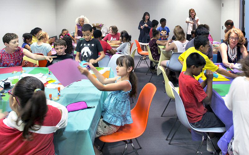 Tang staff help guide the youngsters in making their own artworks in a project called Build a Better World, inspired by their discussion of Nick Cave's Soundsuit. World maps, along with tape and glue, were provided.