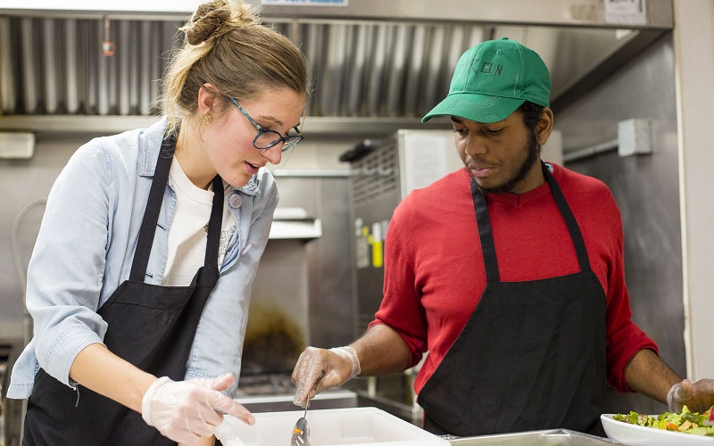 Jen Natyzak, Skidmore's sustainability coordinator for student programming, works with Smith on salad duty.