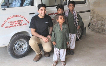 Ibrahim Shah '18 poses with local kids during his summer project to deliver vaccines in his home country of Pakistan.